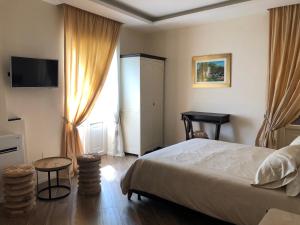 a bedroom with a bed and a tv and a window at Dimora Estlevante in Vieste