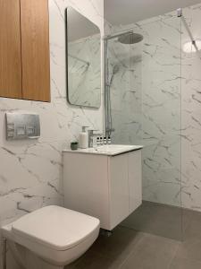 a white bathroom with a toilet and a mirror at Sunny Apartment in Suceava in Suceava