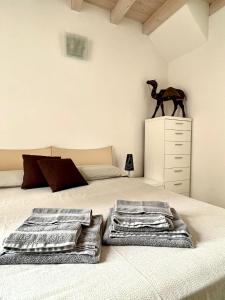 a bedroom with a bed with a horse statue on a dresser at Rossi Lake Family in Oliveto Lario