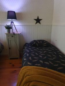 1 dormitorio con 1 cama y una estrella en la pared en Chambre d'hôtes Le Relais de Belloy en Belloy sur Somme