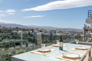 a table with glasses and a bottle of wine at Gk Halepa Luxury apartment in Chania Town