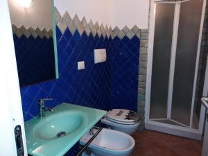 a blue bathroom with a toilet and a sink at Relax al Mare in Olbia