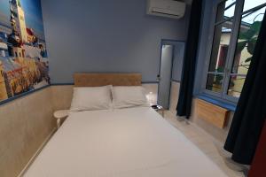 a bedroom with a large white bed with a window at Europe Hôtel in Castres