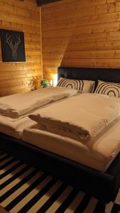a bed in a room with a wooden wall at Ferienhaus-Blockhütte im Fichtelgebirge - Nagler See 2 km in Nagel