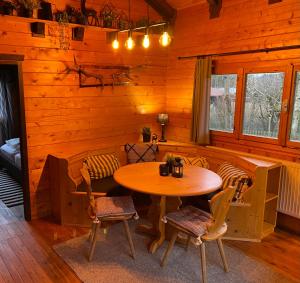 comedor con mesa y sillas en una cabaña en Ferienhaus-Blockhütte im Fichtelgebirge - Nagler See 2 km, en Nagel