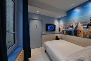 um quarto com uma cama com um quadro na parede em Europe Hôtel em Castres