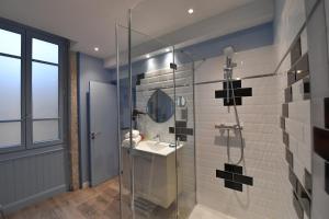 a bathroom with a shower with a sink and a mirror at Europe Hôtel in Castres