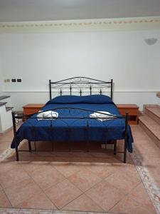 a bed with a blue comforter in a room at Meraviglie Salentine in Lequile