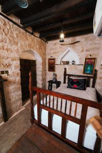a bedroom with a bed in a stone wall at نزل كوفان التراثي Koofan Heritage Lodge in Salalah