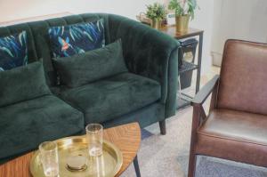 a living room with a green couch and two chairs at Townhouse with private parking in York