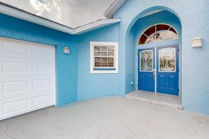 a blue house with a white garage door at Santiago Lane Retreat in Bonita Springs