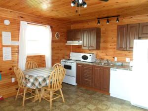 卡文迪西的住宿－Mayfield Country Cottages，厨房配有桌子和白色炉灶烤箱。