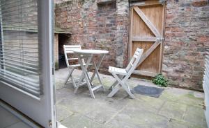 2 Stühle und ein Tisch vor einem Backsteingebäude in der Unterkunft 35 Grosvenor Terrace - 5 min walk from York City Centre in York