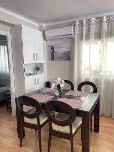 stół jadalny z czarnymi krzesłami i jadalnia w obiekcie Apartamento Ivon Solo Familias w mieście Playa de Gandia