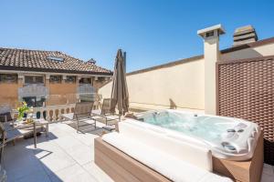 a hot tub on the patio of a house at Crocus Apartments in Sirmione