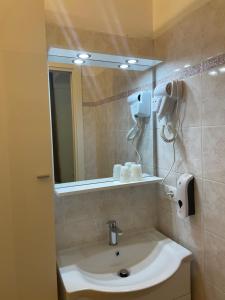 a bathroom with a sink and a mirror at LUVEGU SCIUIU Apartment in Vernazza