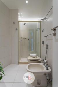 a bathroom with a shower and a toilet and a sink at Apart Hotel no coração do Leblon, com limpeza diária incluída in Rio de Janeiro