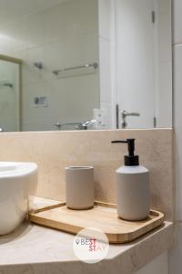 a bathroom with a sink and a soap dispenser on a counter at Apart Hotel no coração do Leblon, com limpeza diária incluída in Rio de Janeiro