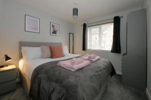 a bedroom with a bed with pink towels on it at Crewe Short Lets 2 Victoria Court, Crewe in Crewe