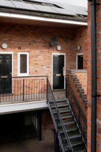 um edifício de tijolos com uma escada que leva a uma porta em Crewe Short Lets 2 Victoria Court, Crewe em Crewe