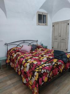 1 dormitorio con 1 cama con un edredón colorido en I Tre Merli, en Dolceacqua