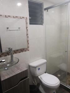 een badkamer met een toilet en een glazen douche bij Apartamento Villavicencio in Villavicencio