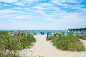 默特爾海灘的住宿－The Splendid South Carolina Getaway，通往海滩的沙滩小径,海滩上配有遮阳伞