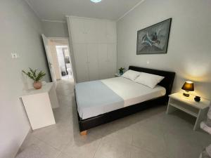 a bedroom with a large bed with a white bedspread at Cozy Apartment in Nea Palatia-Oropos in Oropós