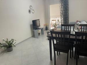 a living room with a dining table and a television at Cozy Apartment in Nea Palatia-Oropos in Oropós