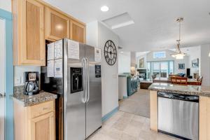 a kitchen with a stainless steel refrigerator and wooden cabinets at EazyBreezy in Rockaway Beach