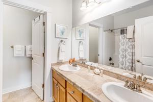 a bathroom with two sinks and a large mirror at EazyBreezy in Rockaway Beach +29 photos