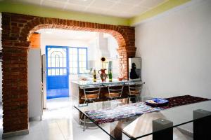 een keuken met een glazen tafel en een bakstenen muur bij Casa Hogareña y Artística in Carrillo