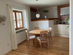 eine Küche mit einem Holztisch und Stühlen im Zimmer in der Unterkunft Watzmannkar in Bischofswiesen