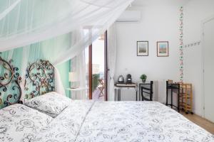 una camera con un letto bianco e una finestra di Tauromenion Guest House a Taormina