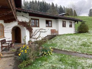 una casa blanca con un patio con flores amarillas en Watzmannkar en Bischofswiesen