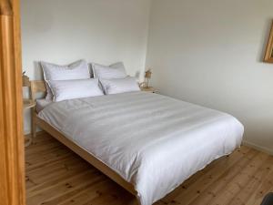 a bed with white sheets and pillows in a room at Watzmannkar in Bischofswiesen