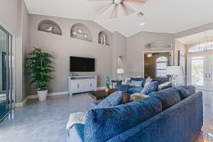 uma sala de estar com um sofá azul e uma televisão em Palmetto Canal em Cape Coral