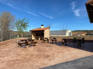 a group of picnic tables and a stone fireplace at Casas del Barranco de la Hoz in Ventosa