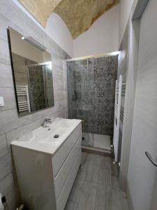 ein weißes Bad mit einem Waschbecken und einer Dusche in der Unterkunft I Tre Merli in Dolceacqua