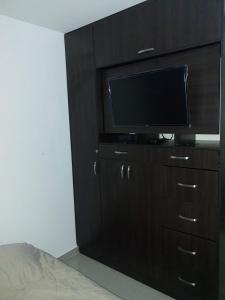 een zwart entertainmentcentrum met een flatscreen-tv bij Apartamento Villavicencio in Villavicencio