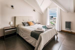 Un dormitorio con una cama grande y una ventana en Riviera Fueguina Apartments en Ushuaia