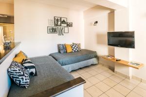 uma sala de estar com um sofá e uma televisão de ecrã plano em Riviera Fueguina Apartments em Ushuaia