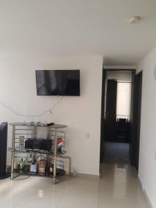 een woonkamer met een tv aan een witte muur bij Apartamento Villavicencio in Villavicencio
