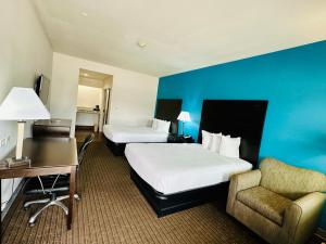 El Campo的住宿－Lonestar Inn，酒店客房 - 带两张床、一张桌子和一把椅子