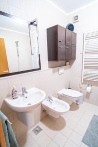 a white bathroom with a sink and a toilet at Apartment Cosmopolitan in Zadar