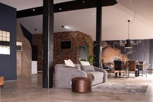 a living room with a couch and a brick wall at KiMMCo Loft in Schwetzingen