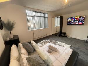 uma sala de estar com um sofá e uma televisão em Casa Lobo's Beautiful Suites Apartment 1 free offroad parking em Fallings Park