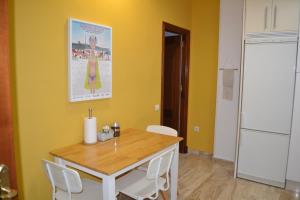 cocina con mesa, sillas y pared amarilla en Apartamento Posidonia Free Parking, en Cádiz