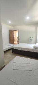 ein großes Schlafzimmer mit 2 Betten und einem Tisch in der Unterkunft Cabañas vacacional El Porvenir in San Antero