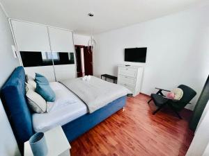 ein Schlafzimmer mit einem blauen Bett und einem Stuhl in der Unterkunft City View Luxury Apartment in Banská Bystrica